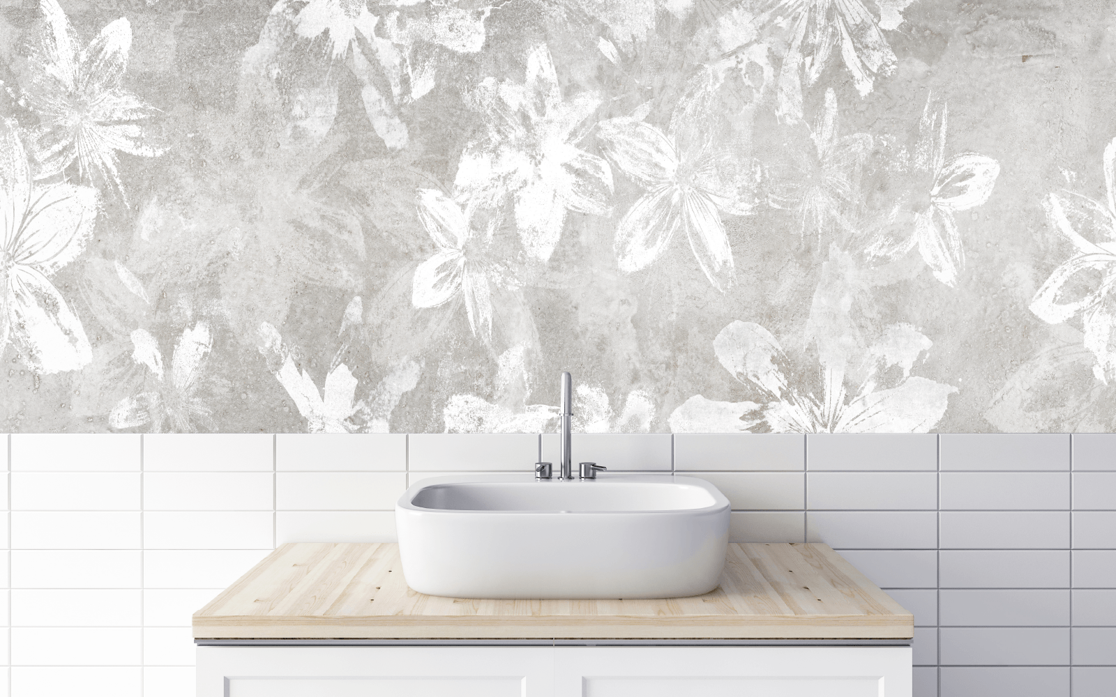Graphic of white flowers on a concrete wall above and behind a vessel sink on a light wood and white vanity in front of parallel tiles.